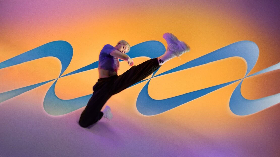 An athletic woman poses mid-air against a gradient orange and purple backdrop with blue stylized swooshes and white athletic shoes.