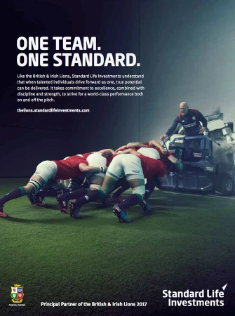 Rugby team scrumming on field, coach driving mini-tractor with rubble; Standard Life Investments ad for British & Irish Lions.