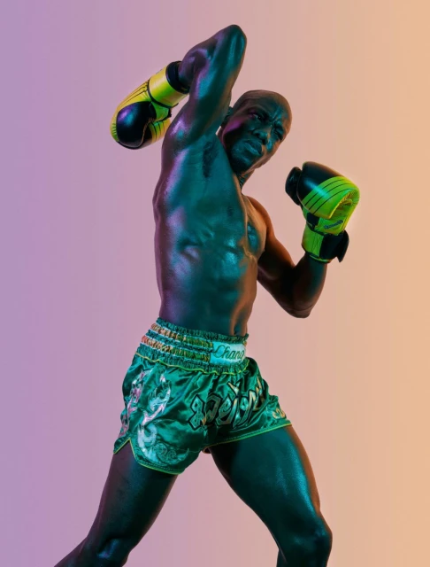 Muscular man in boxing stance with gloves and shorts in studio lighting, capturing a dynamic, athletic moment with vibrant colors.