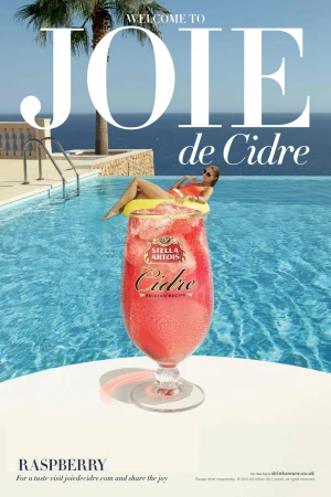Beverage ad with a cocktail glass in front of a pool and an adult female in a pool float with ocean and sky background.