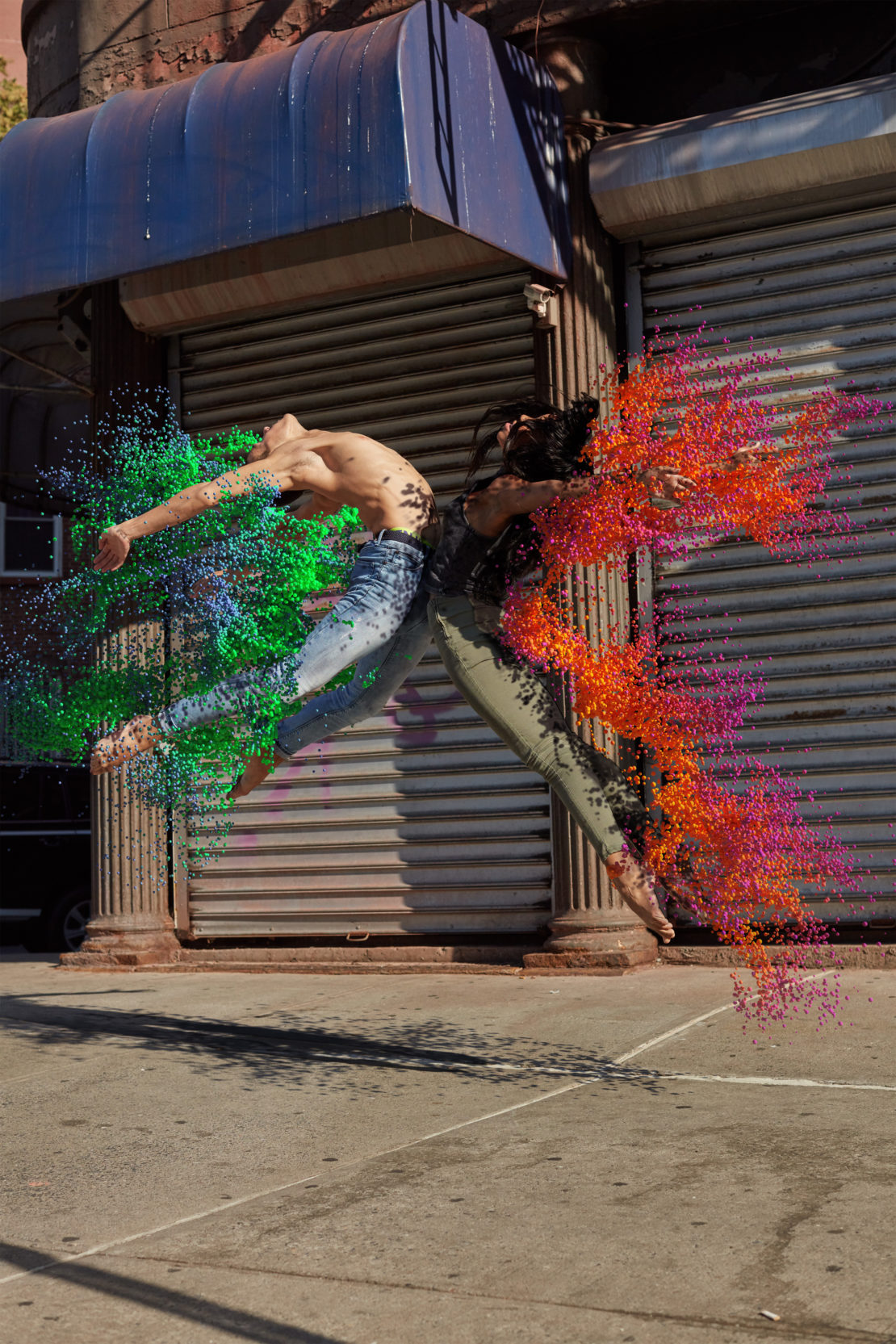 Two performers leap in a city street with surreal paint effects, against a backdrop of urban architecture, blending dance and digital art.