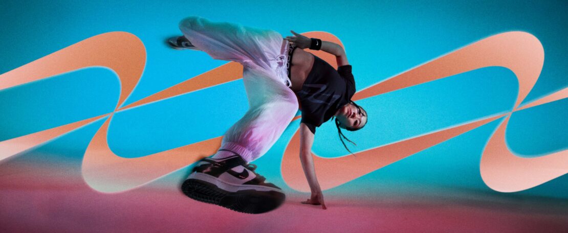 Female breakdancer in mid-air pose, wearing athletic wear against an abstract teal and orange background. Sports and dance concept.