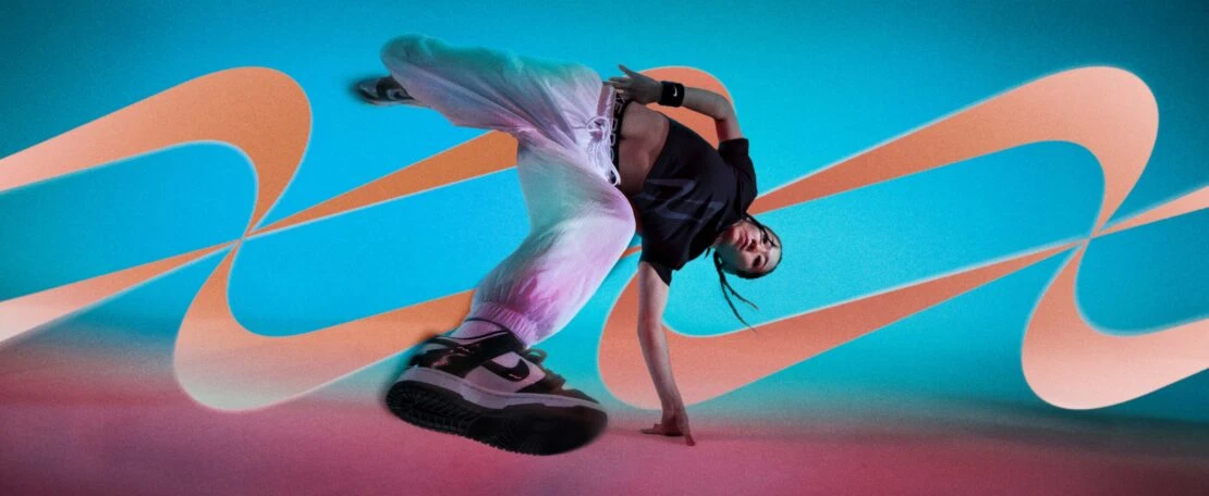 Female breakdancer in mid-air pose, wearing athletic wear against an abstract teal and orange background. Sports and dance concept.