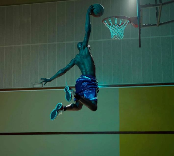 A shirtless basketball player in mid-air with a ball, poised to dunk, with dramatic turquoise lighting and a green-toned court.