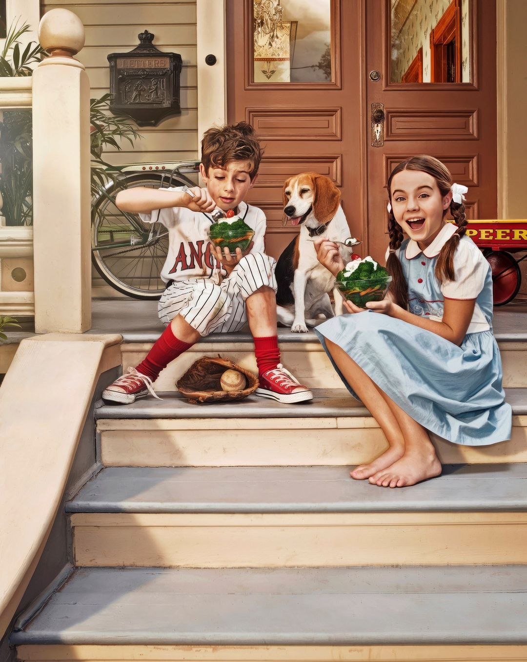 Boy and girl sitting on porch stairs enjoying desserts with a beagle dog, baseball glove and bat, in a lighthearted outdoor scene.