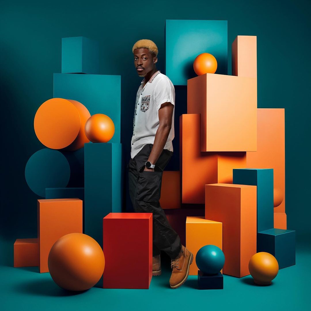 Stylish portrait of a young Black man surrounded by geometric blocks and spheres in orange, blue, and red against a teal backdrop.