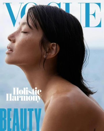 Profile portrait of a woman with freckles and closed eyes outdoors against an ocean background by photographer Amie Milne.
