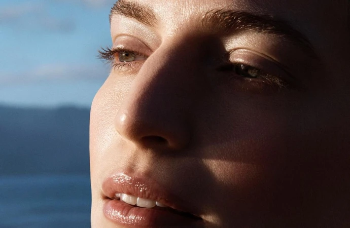 Close-up portrait of a woman face with natural glowing skin in golden hour sunlight photographed by Amie Milne