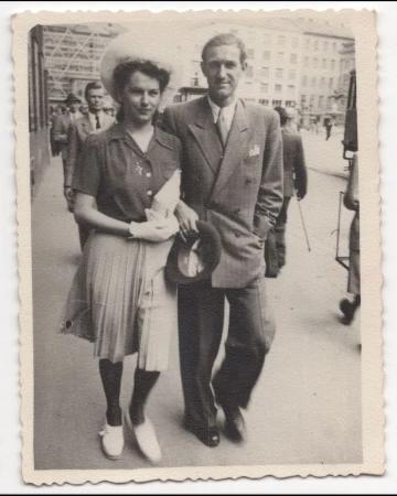 Vintage black and white photograph of a man and woman walking together on a city street by Adrian Mesko