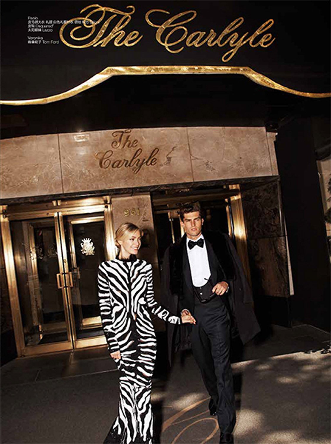 A fashionable couple in evening wear poses outside The Carlyle hotel entrance, showcasing elegant attire and urban sophistication.