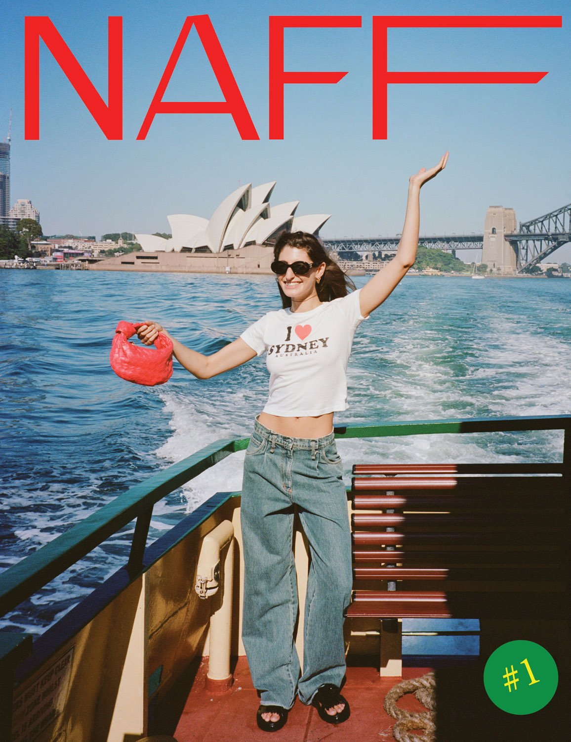 Woman on boat with Sydney Opera House and Harbour Bridge in background. She wears a white top, jeans, and holds a red purse.