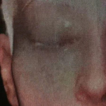 Extreme close-up portrait of a person showing visible screen pixelation and digital grid texture across their face.