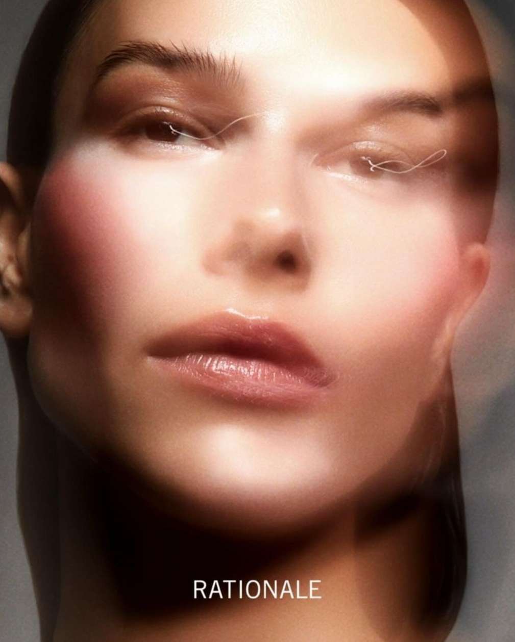 Close-up beauty portrait of a woman with blurred glowing skin effects and minimal makeup by Justin Ridler.