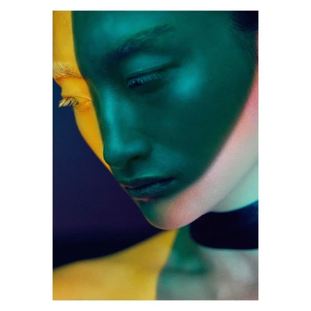Portrait of a woman's face in half yellow and half green lighting, close-up shot with black choker and vibrant, dual-color illumination.