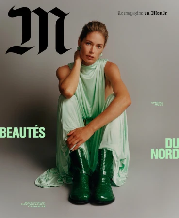 Fashion magazine cover featuring a female model in a green dress and boots, sitting on the floor against a grey background.
