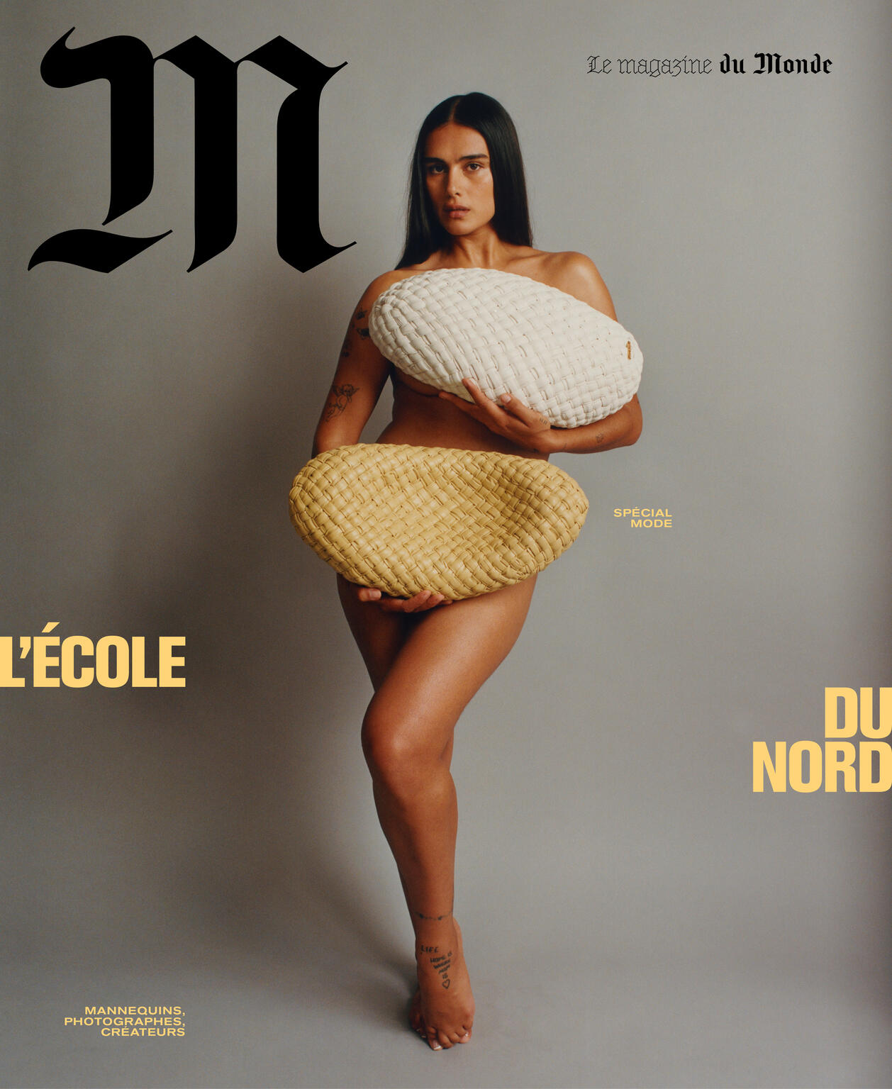 Magazine cover with a nude woman holding a large woven bag and an ecru pillow, set against a gray background with magazine text.