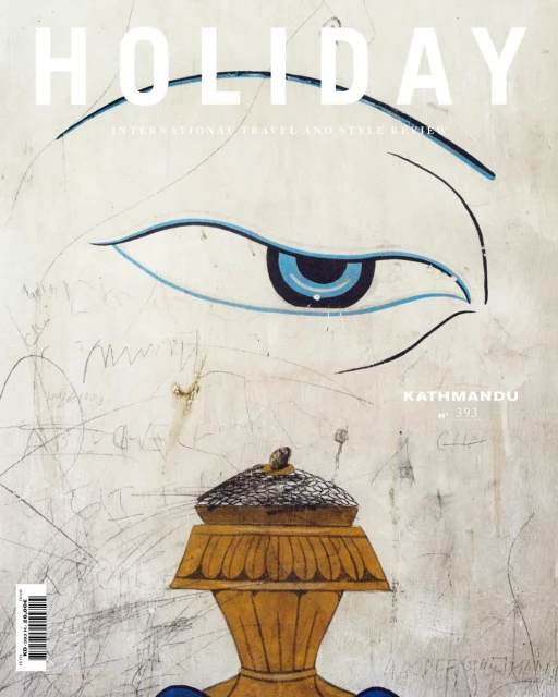 Magazine cover with an illustration of an eye, golden vase, and the text 'Holiday International Travel and Style Review'.