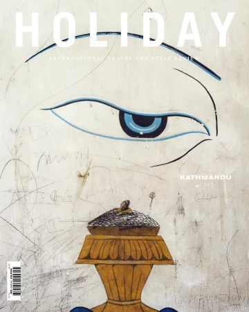 Magazine cover with an illustration of an eye, golden vase, and the text 'Holiday International Travel and Style Review'.