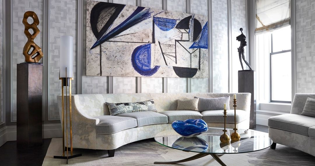 Interior view of a modern living room featuring a curved sofa, abstract art, and designer decor, creating a sophisticated and stylish ambiance.