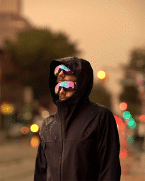 Surreal portrait by Romain Laurent featuring a man in a black jacket wearing iridescent ski goggles stacked on top of each other