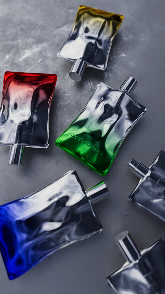 Overhead studio shot of an arrangement of glass perfume bottles with silver caps filled with red, green, blue, and yellow liquid.