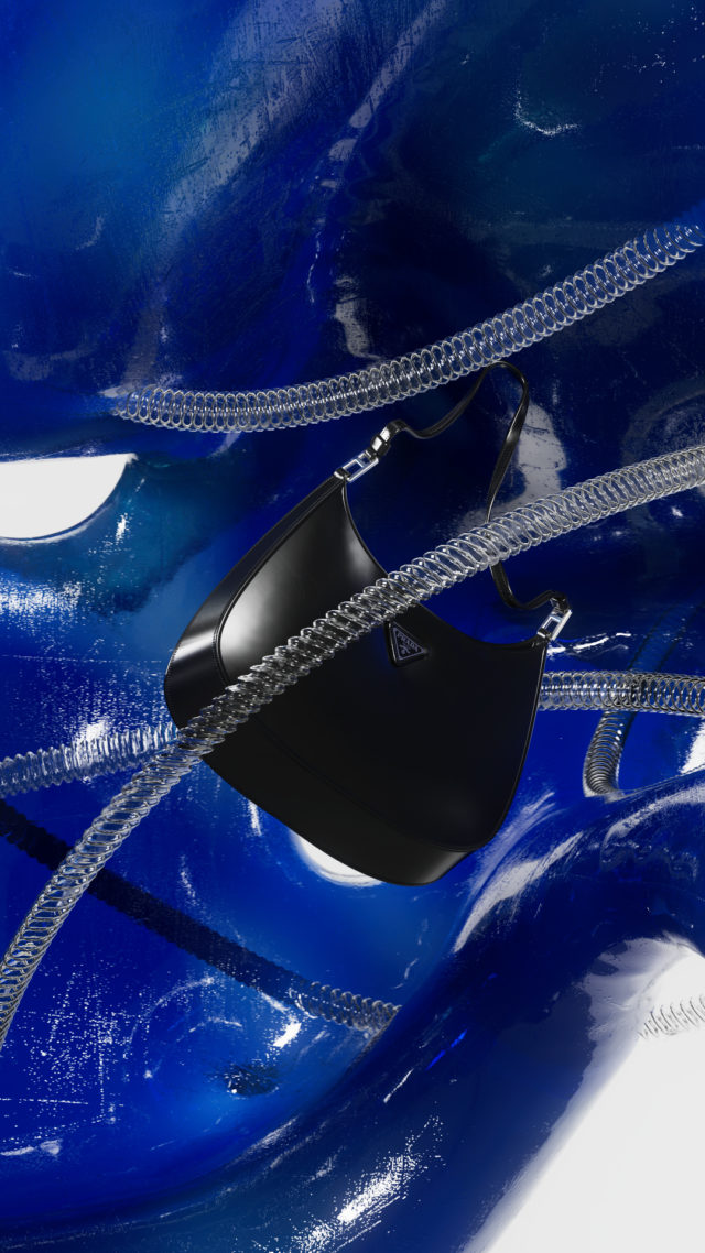 Black Prada purse showcased against a swirling blue backdrop with translucent tubing, creating a modern, high-fashion aesthetic.