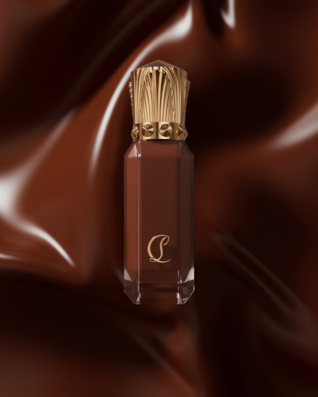 Beauty shot of a brown liquid lipstick in a clear container with a gold cap against a shiny, dark brown background.