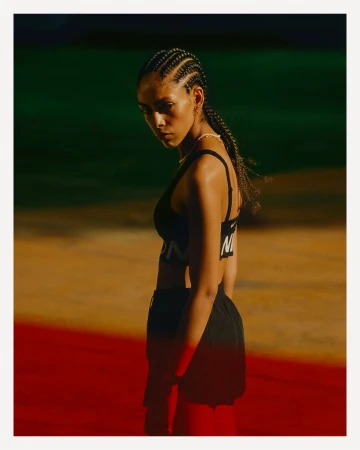 Athletic woman with braided hair wearing a black sports bra and shorts photographed by Mark Bramley in Sydney.