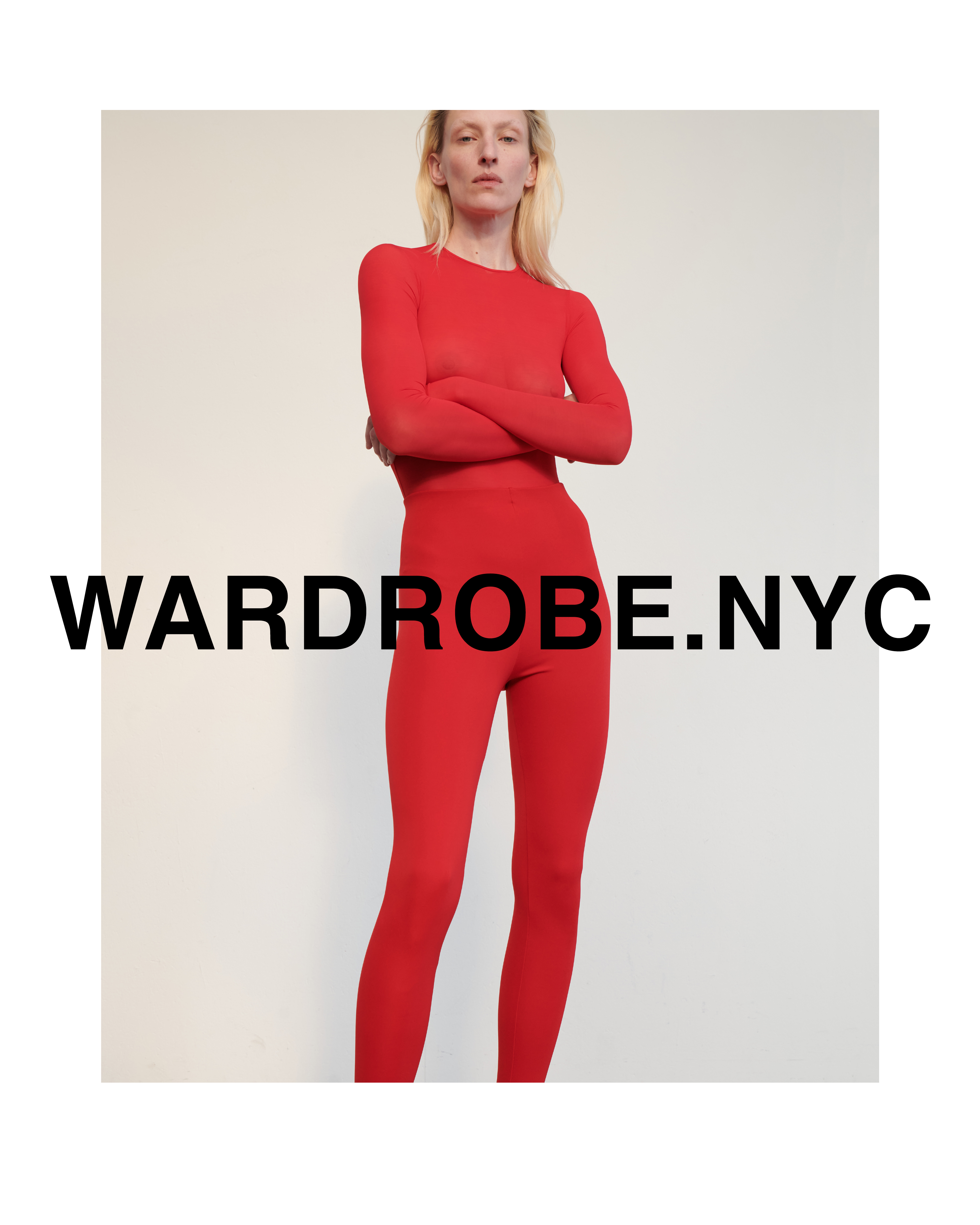 A fair-skinned woman in a red long-sleeved top and leggings stands against a neutral background. Wardrobe.nyc text overlay.