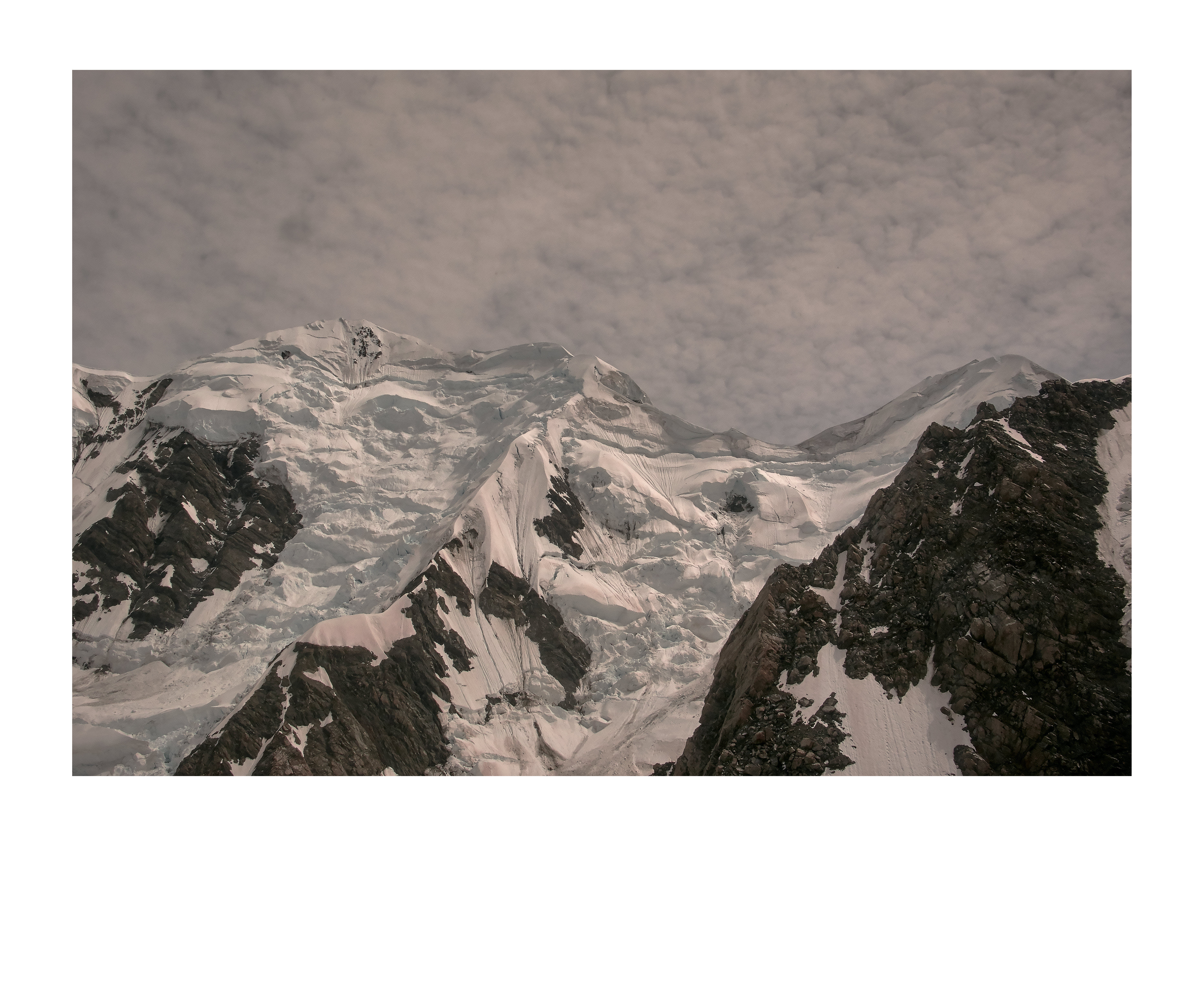 Scenic mountain landscape with snow and rocks under a cloudy sky, capturing the natural beauty of the alpine environment.