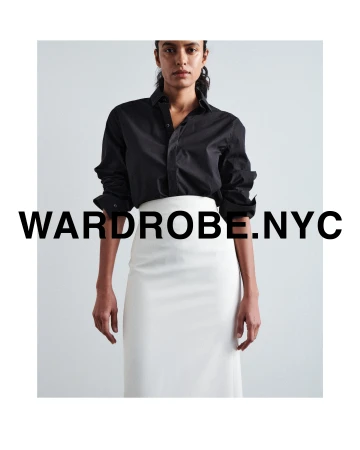 Model wearing a black button-up shirt and white skirt against a plain background with bold text