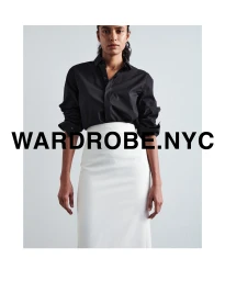 Model wearing a black button-up shirt and white skirt against a plain background with bold text