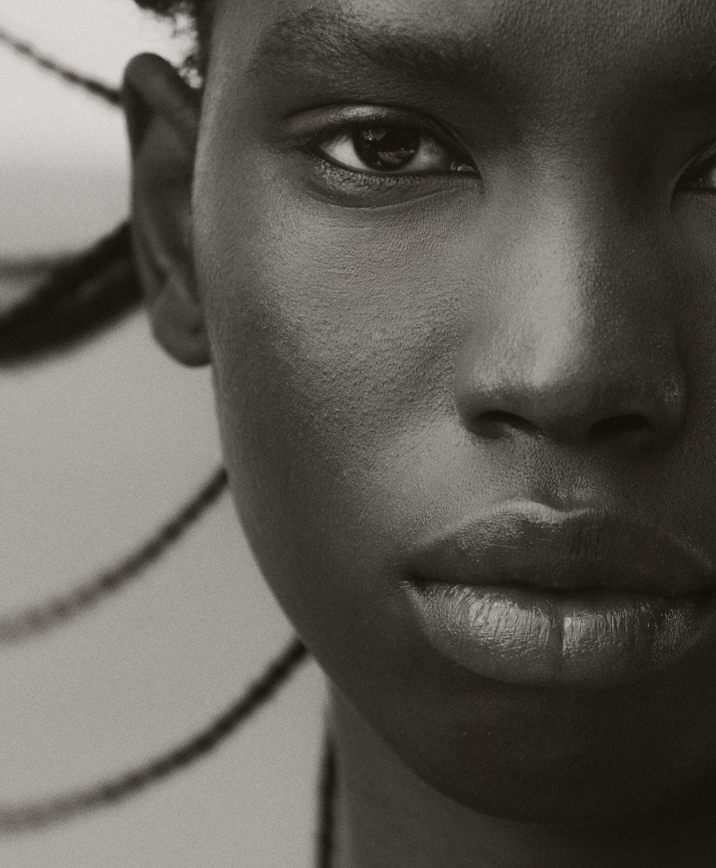 Striking black and white close-up portrait of an African American woman with sleek hair, capturing her serene expression and skin texture.
