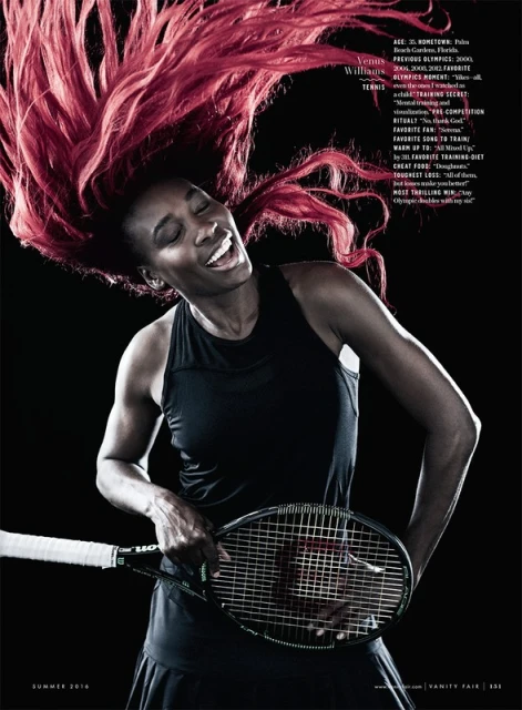 Portrait of Venus Williams holding a tennis racket with her red hair flying above her head against a black background.