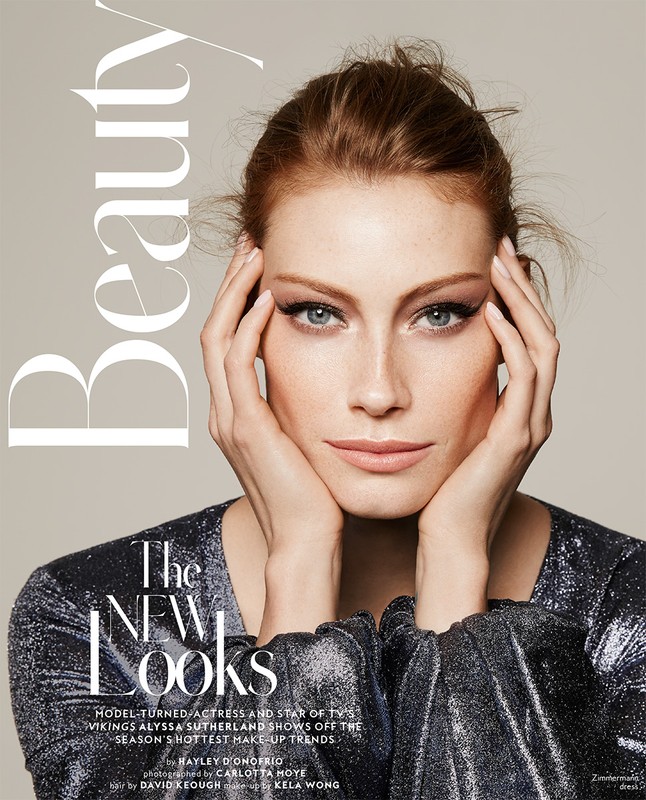Close-up studio portrait of a fair-skinned red-haired woman with hands on her face, wearing a shiny top. Beauty magazine cover.