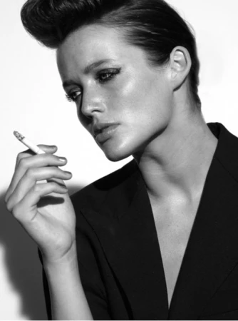 Black and white portrait of a woman holding a cigarette wearing a dark blazer, styled by David Keough in Los Angeles