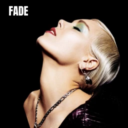 Close-up profile of a woman with blonde hair, green eyeshadow, and dark red lipstick wearing silver jewelry against a black background.