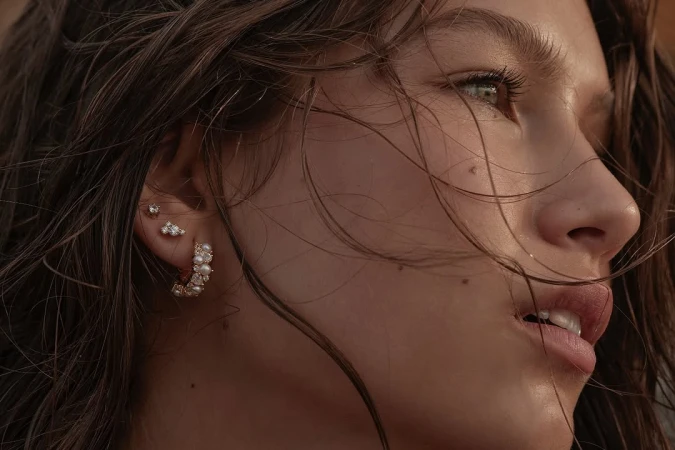 Close up profile portrait of a woman with wet hair wearing delicate pearl and diamond earrings photographed by Emily Abay.