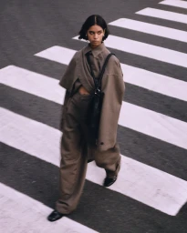 Woman in brown coat and trousers walking across a zebra crossing in Sydney photographed by Lewis Stevenson.