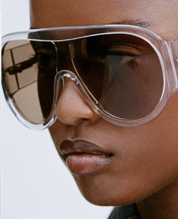 A close-up of an African American woman wearing clear-framed sunglasses, showcasing fashion, beauty, and a focus on eyewear details.
