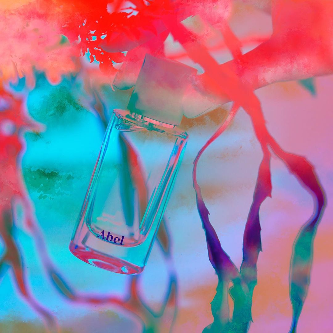 Abstract digital art of a clear glass filled with water against a swirling backdrop of teal, pink, and red tones. 