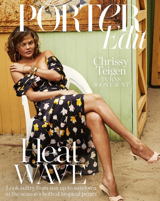 Chrissy Teigen on a 'Porter Edit' magazine cover sitting in a chair with a floral dress, gold jewelry, and tan sandals with an outdoor backdrop.