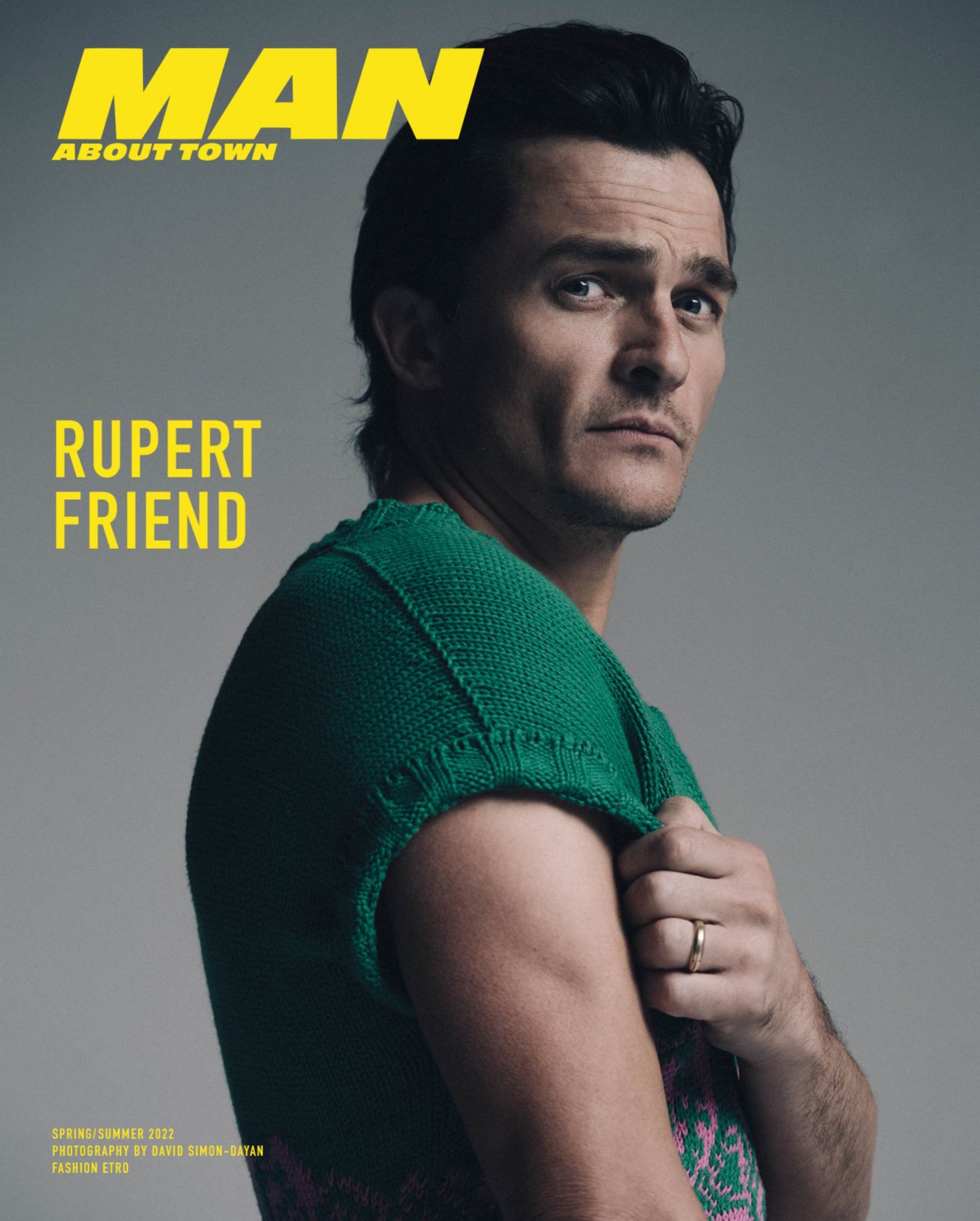 Magazine cover featuring a male model, Rupert Friend, in a green knit sweater. The cover includes the magazine title 'MAN About Town'.