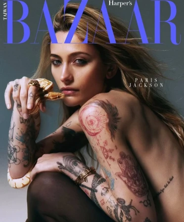 Paris Jackson, partially bare-shouldered, holds a yellow and white snake, against a gray background, on the cover of Taiwan Bazaar.