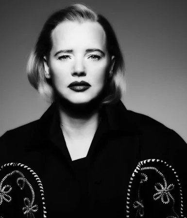 Close-up monochrome portrait of a woman wearing a dark patterned jacket and dramatic dark lipstick.