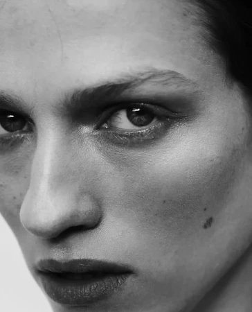 Monochrome close-up portrait of a woman's face highlighting natural skin texture and subtle make-up.