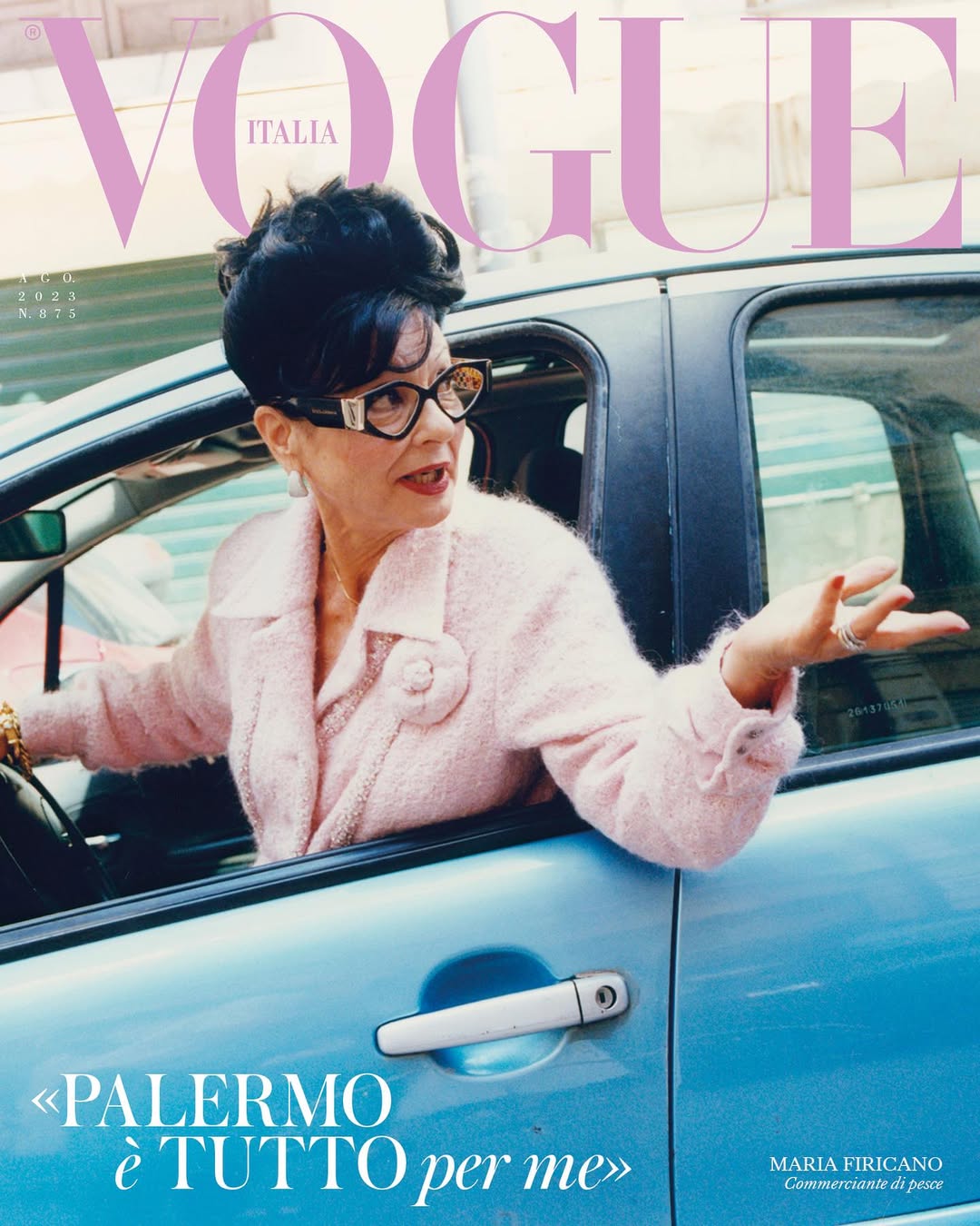Vogue Italia cover featuring an adult woman with dark hair in a car, wearing a pink jacket and eyeglasses, with the magazine's masthead visible.