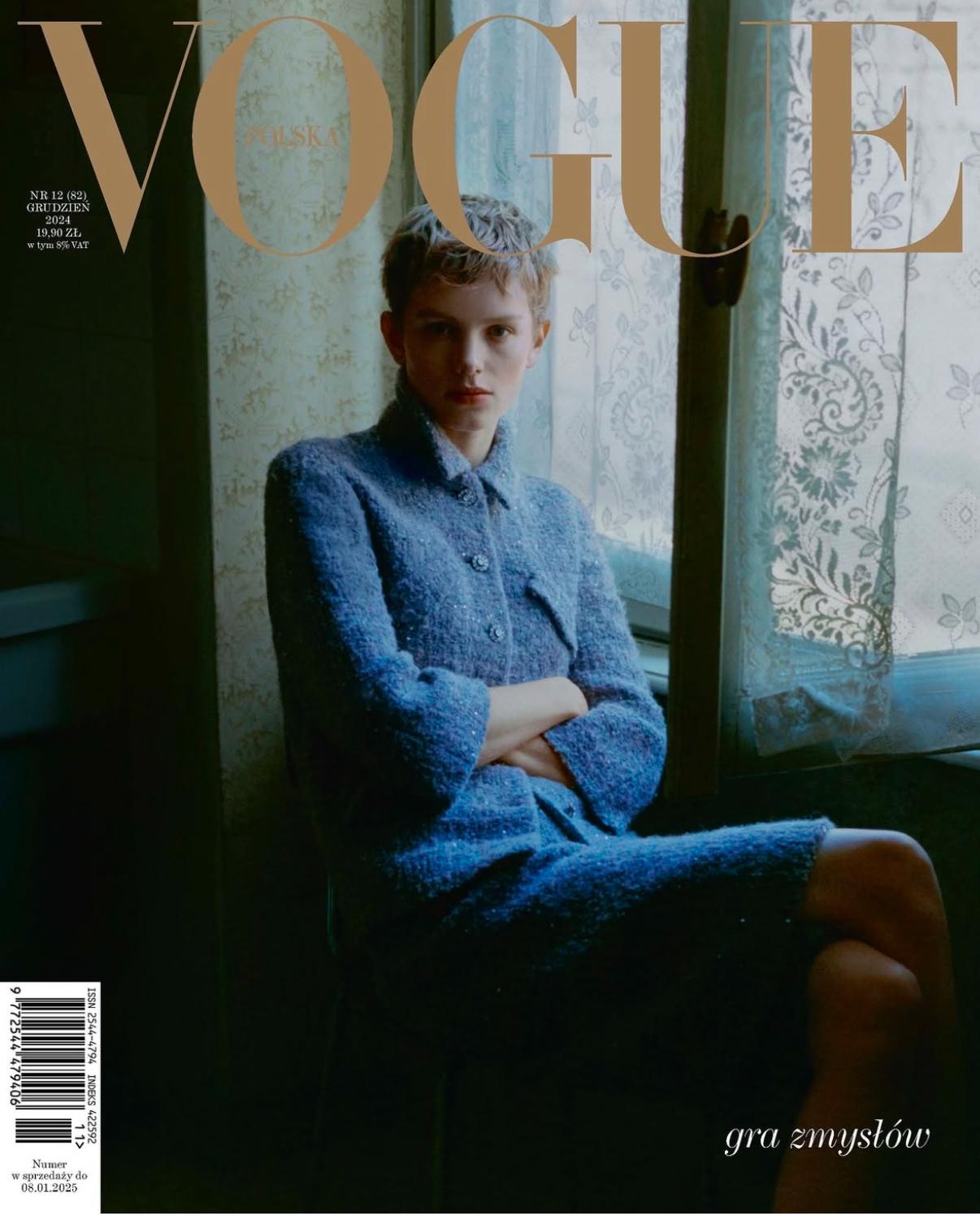 Vogue Polska cover featuring a fair-skinned female model with short hair in a blue tweed skirt suit, seated by a window with lace curtains.