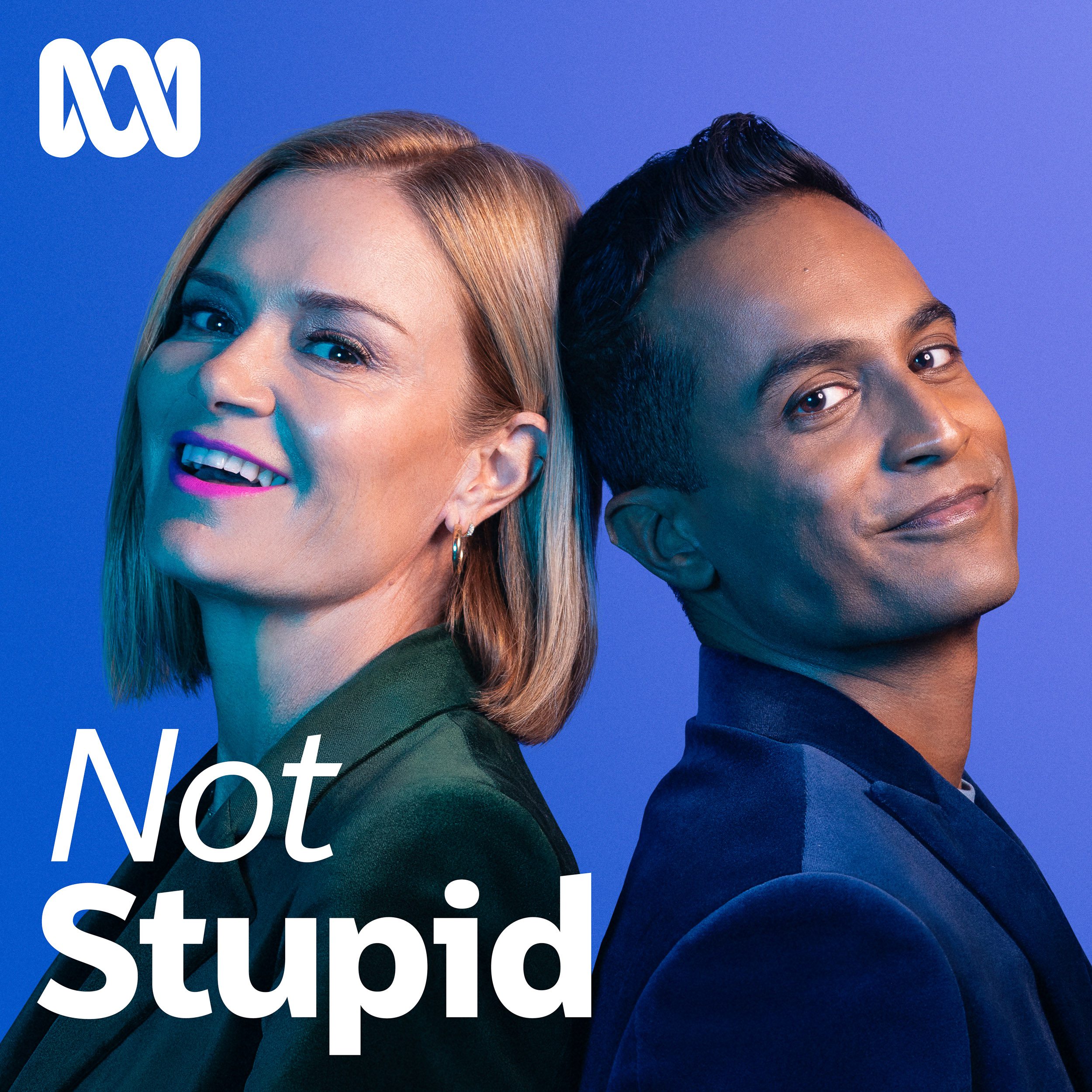 Headshot of a smiling woman and man back-to-back against a blue background, promoting 'Not Stupid' podcast, showcasing a relaxed and inviting mood.