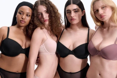 Four diverse female models wearing bras in various shades against a clean white backdrop